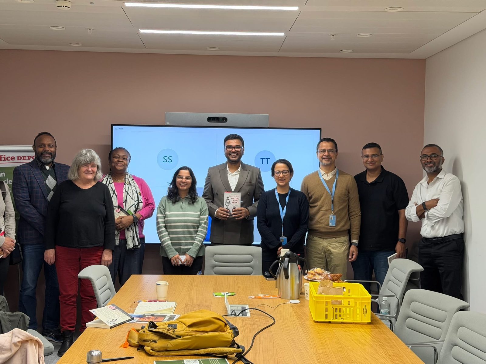 Anand Priya Deo holding Follow Your Heart with UN staff and former colleagues at the Geneva launch