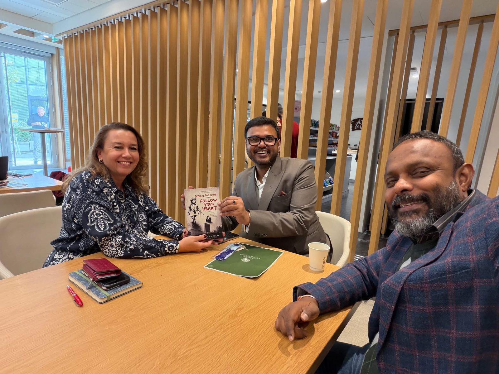 Anand Priya Deo presenting a copy of Follow Your Heart to a colleague in Geneva