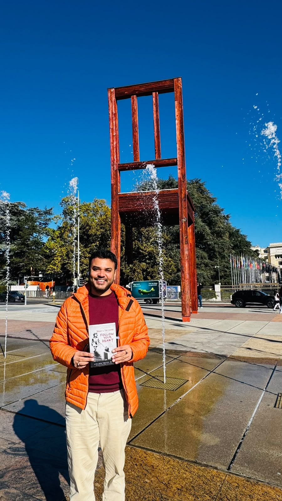 Anand Priya Deo holding Follow Your Heart at the Broken Chair outside the UN Palais des Nations, Geneva